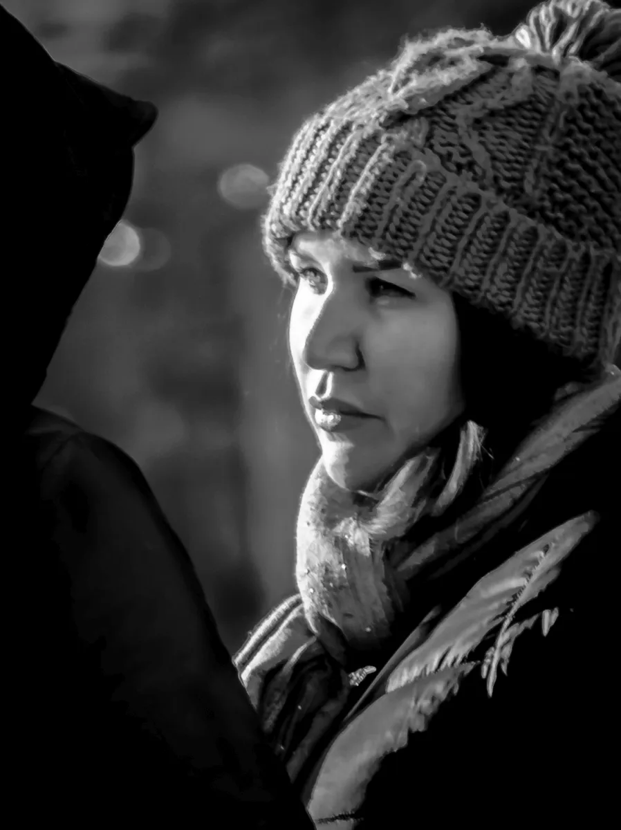 Woman in a knit hat looking past the camera in winter light
